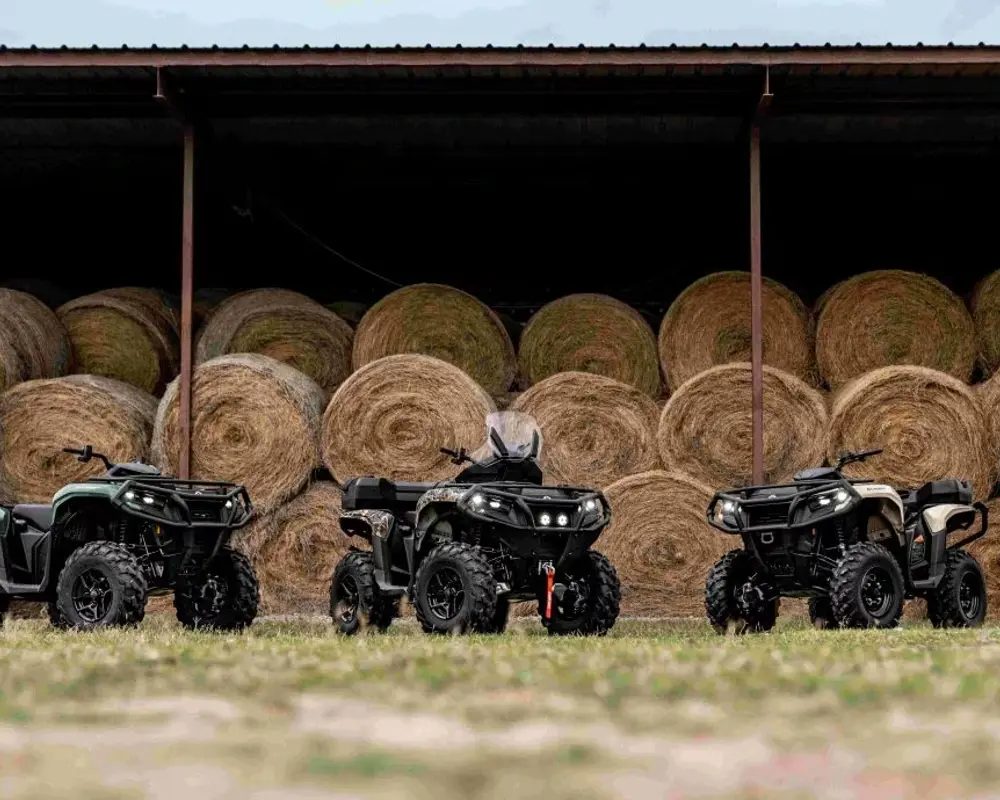 Tre fyrhjulingar framför höbalar